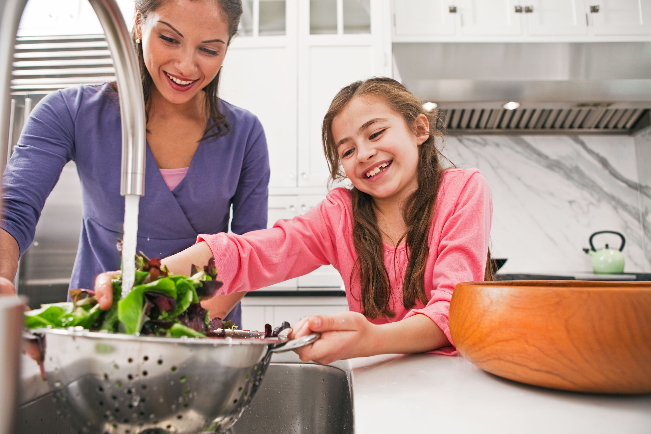 Mother and Daughter Making Salad in the Kitchen by photographer, Michael Weschler